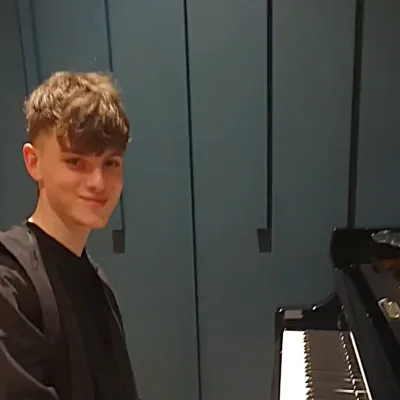 Young man smiling at piano