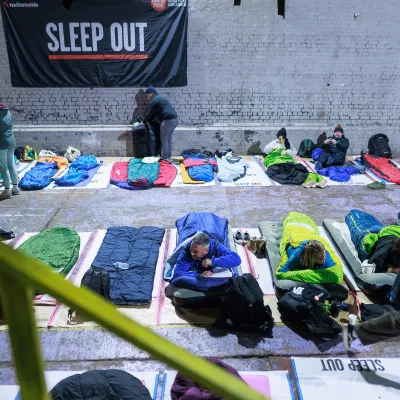 Participants at Manchester Sleep Out getting into sleeping bags
