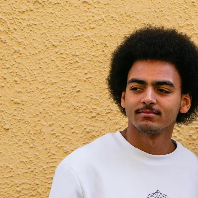 Young man standing in front of yellow wall