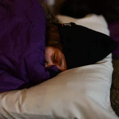 woman in sleeping bag sleeping on pillow