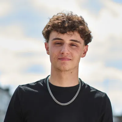 Young person standing outside and looking directly at camera