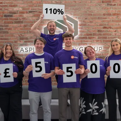 group of 6 corporate sleep out participants hold up their fundraising total: £5500
