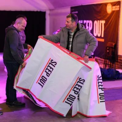 Sleep out participants handing out mats