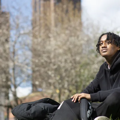 A young person sits outside on a sunny day