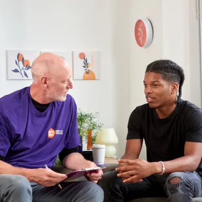 A young person in supported housing talks to a Centrepoint staff member