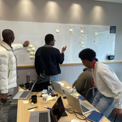 Young people take part in a workshop with Nationwide and post ideas on a whiteboard