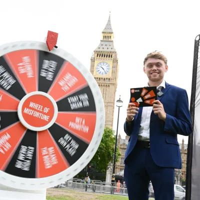Gameshow hosts stands by a wheel