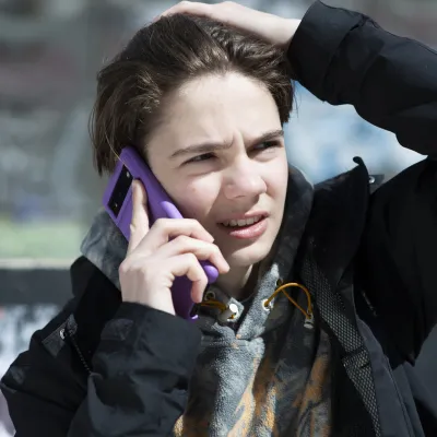 A young person in the street is on a call on their mobile phone