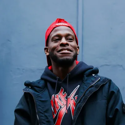 Young man in a red hat standing in front of a wall