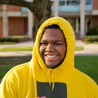 Young man smiling in a yellow jumper