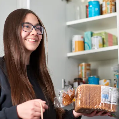 A young person unpacks shopping at home