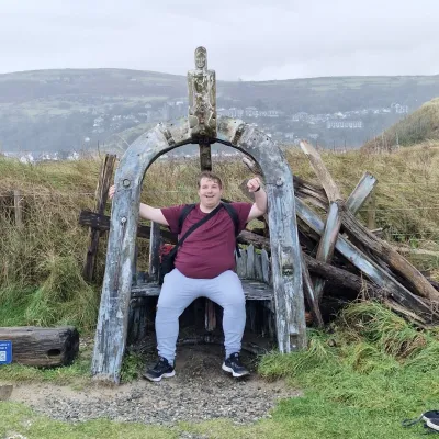 Young man sat on a wooden bench