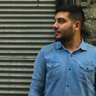Man standing in front of wall looking to the side