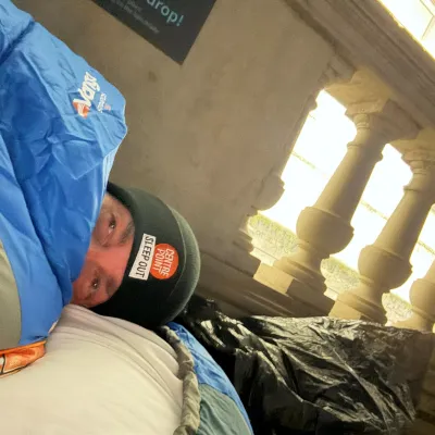 Sleep Out participant in sleeping bag with sleep out hat