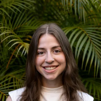 Young woman smiling in front of green plants