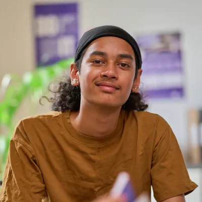 A young person smiles while chatting with a Centrepoint support worker