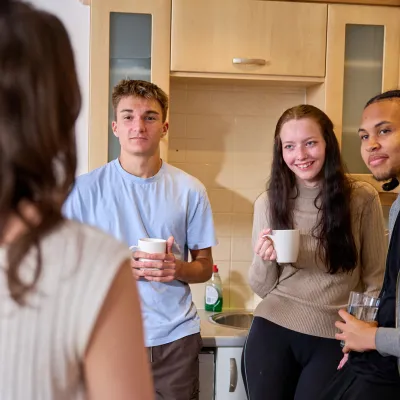 Young people chat in the kitchen of their shared home